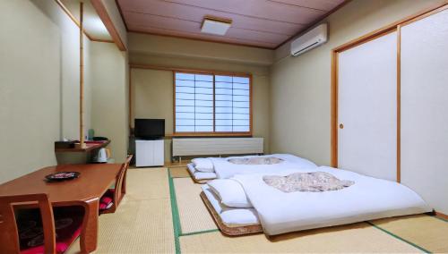 una habitación con dos camas y un escritorio y una mesa en Berjaya Hakkoda Ski Resort, en Aomori