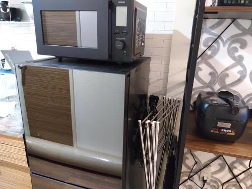 a microwave oven sitting on top of a cabinet at BetterЯ03青森橋本203号室 in Aomori