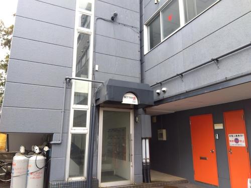 a building with orange and orange doors on it at BetterЯ03青森橋本208号室 in Aoki