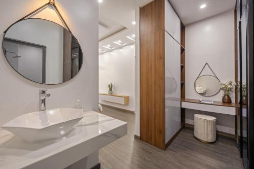 a bathroom with a sink and a mirror at Hùng Villa 5br Full Ac Quite -Rooftop Pool- Bida- New in Da Nang