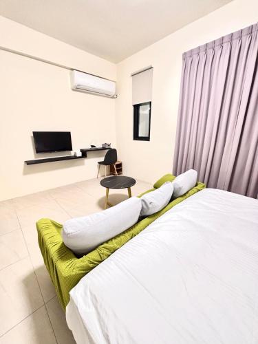 a bedroom with a white bed with a green couch at 玉里步道民宿 in Yuli