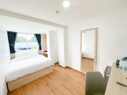 a bedroom with a bed and a large window at H-Banaat Hotel in Bangkok