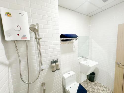 a white bathroom with a toilet and a sink at H-Banaat Hotel in Bangkok