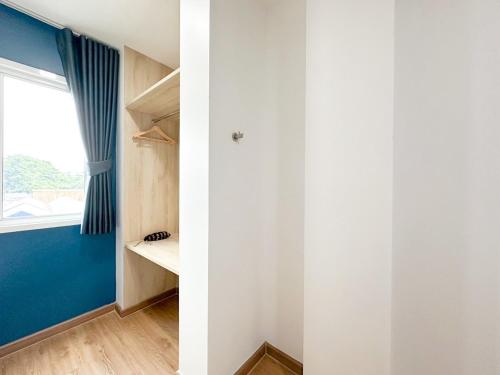 a room with a blue wall and a window at H-Banaat Hotel in Bangkok