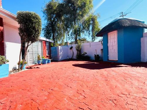 a house with a blue building and a dirt yard at Executive Accommodation Bellville 2 in Cape Town