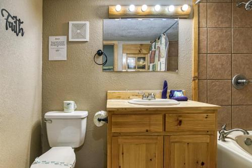 a bathroom with a toilet and a sink and a mirror at Deer To My Heart, Free Attraction Tickets, Hot Tub, Arcade, Air Hockey, WIFI!!! in Sevierville