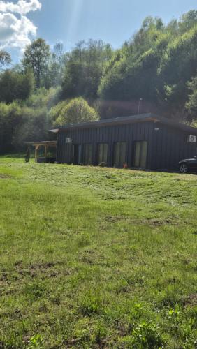 a building in the middle of a grass field at Cabana Bendis in Suciu de Sus