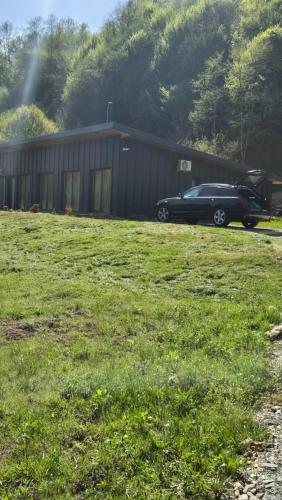 a car parked in a field next to a building at Cabana Bendis in Suciu de Sus