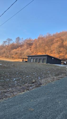 a building in the middle of a field at Cabana Bendis in Suciu de Sus