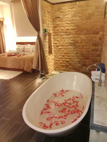 a bath tub in a room with a bed at Muaya Villa in Jimbaran