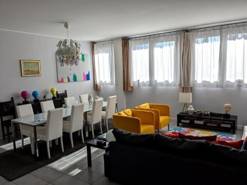a living room with a couch and a table and chairs at Beautiful new apartment with private entrance and parking 5 min walking from center in Bellano