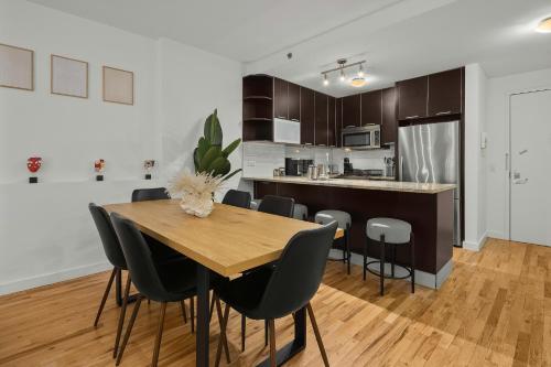 a kitchen and dining room with a wooden table and chairs at Modern 2BR Steps from New York's Iconic Broadway in New York