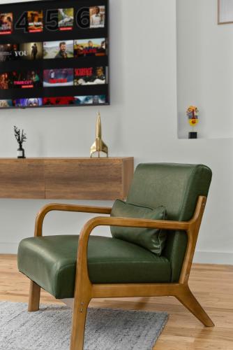 a green chair sitting in a living room at Modern 2BR Steps from New York's Iconic Broadway in New York