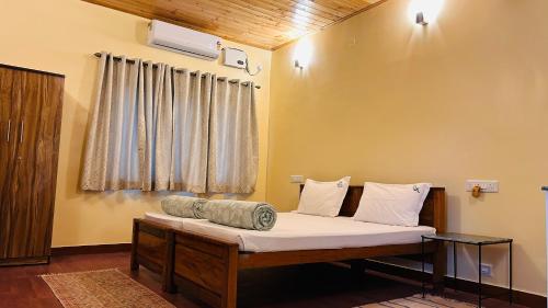 a bed in a room with a window at Tamarind Tree Masinagudi in Masinagudi