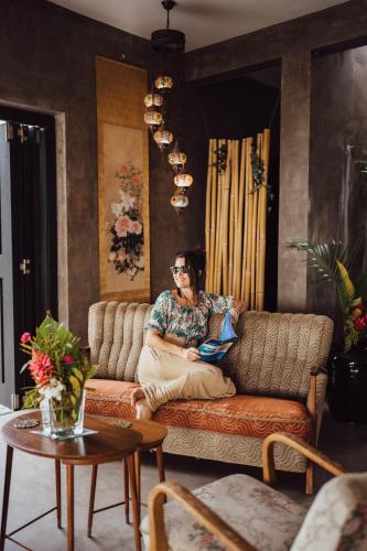 a woman sitting on a couch in a living room at South Pacific Memories in Port Vila