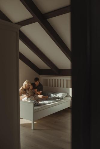 a man and a woman laying on a bed at Berti in Upesgrīva