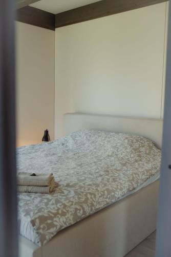 a bedroom with a white bed with a white comforter at Berti in Upesgrīva