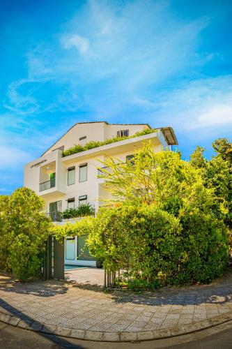 a white building with trees in front of it at HA Gateway Inn Hoian Priavate Pool Villa in Hoi An