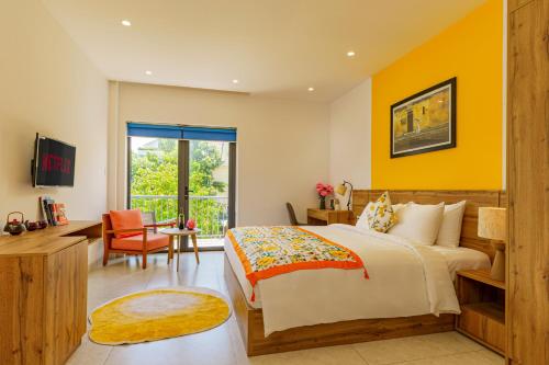 a bedroom with a large bed with yellow walls at HA Gateway Inn Hoian Priavate Pool Villa in Hoi An