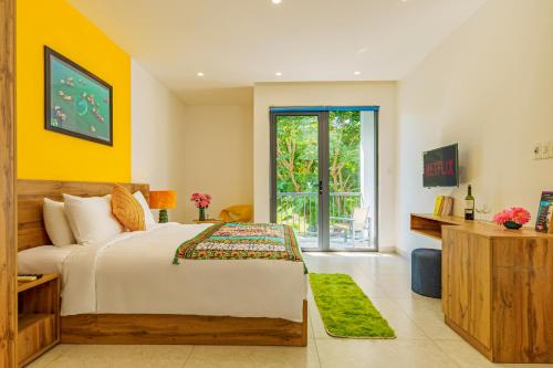 a bedroom with a large bed with yellow walls at HA Gateway Inn Hoian Priavate Pool Villa in Hoi An