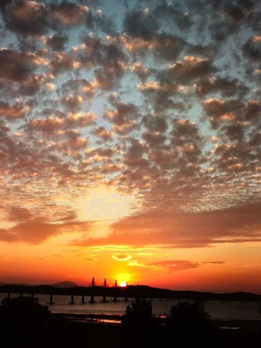 a sunset with the sun setting in the sky at 飛鳥集行館 in Hu-hsia