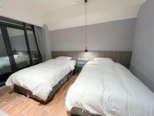 a bedroom with two beds and a mirror at 飛鳥集行館 in Hu-hsia