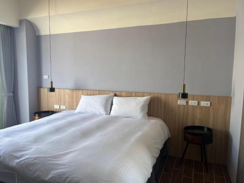 a bedroom with a large bed with white sheets at 飛鳥集行館 in Hu-hsia