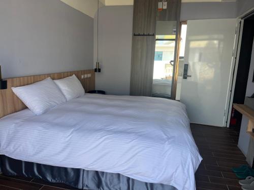 a bedroom with a white bed and a window at 飛鳥集行館 in Hu-hsia