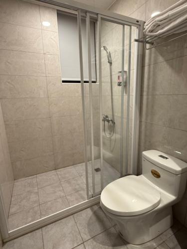 a bathroom with a toilet and a glass shower at 飛鳥集行館 in Hu-hsia
