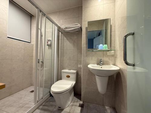 a bathroom with a toilet and a sink and a shower at 飛鳥集行館 in Hu-hsia