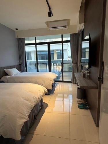a hotel room with three beds and a window at 飛鳥集行館 in Hu-hsia