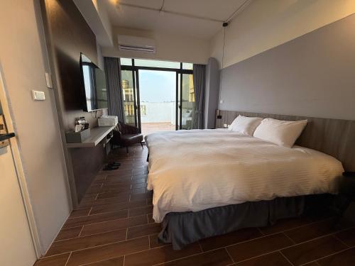 a bedroom with a large bed and a large window at 飛鳥集行館 in Hu-hsia