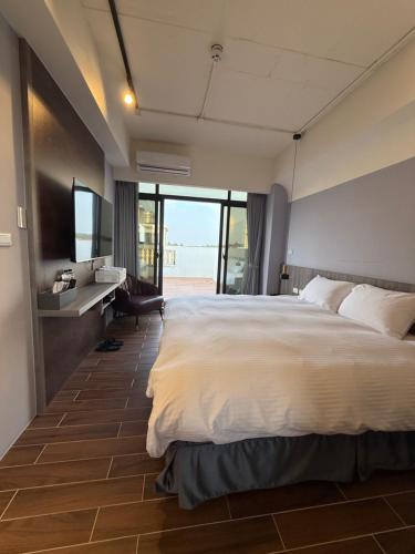 a bedroom with a large white bed and a bathroom at 飛鳥集行館 in Hu-hsia