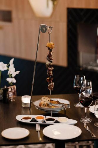 a table with a plate of food and wine glasses at The Remington Orange in Orange