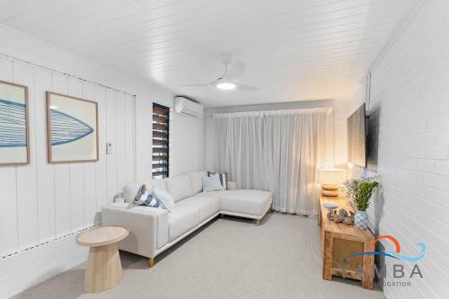 un salon avec un canapé blanc et une table dans l'établissement Stella LJHooker Yamba, à Brooms Head