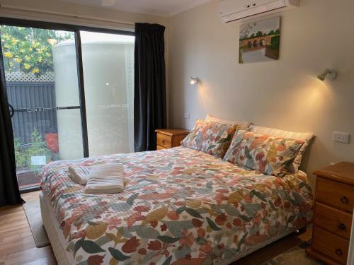 a bedroom with a bed and a large window at Vale Stay in McLaren Vale