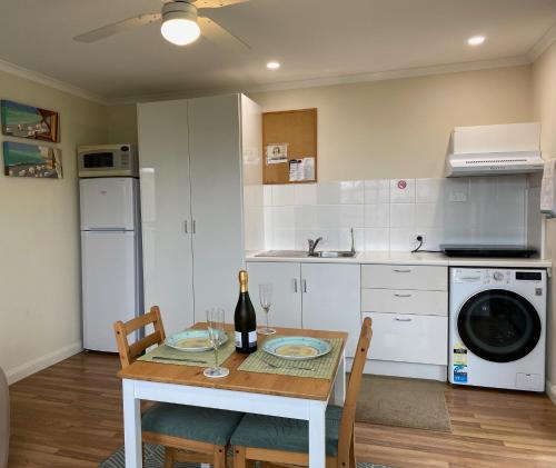 a kitchen with a table with a bottle of wine at Vale Stay in McLaren Vale