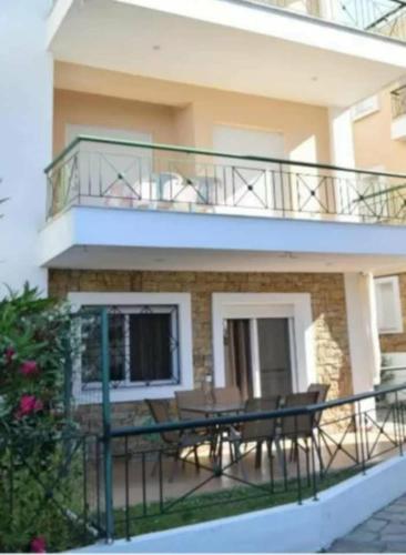 a balcony with a table and chairs in front of a building at Nikoleta Summer Glow in Kriopigi
