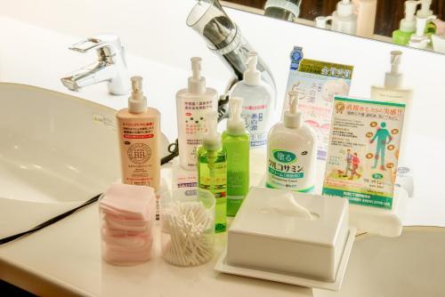 a bathroom counter with a sink and a bunch of cleaning products at Diamond Hakone Society in Hakone