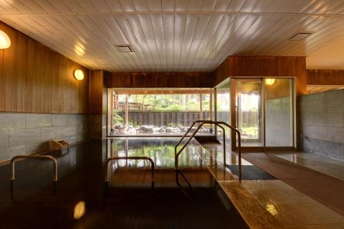 a pool of water in a room with a window at Diamond Hakone Society in Hakone