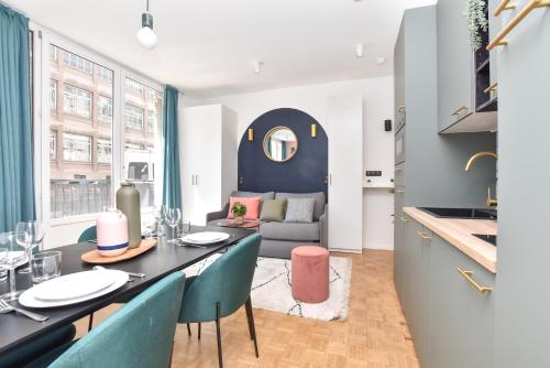 une cuisine et un salon avec une table et des chaises dans l'établissement Charming and cosy flat next to the Eiffel Tower, à Paris
