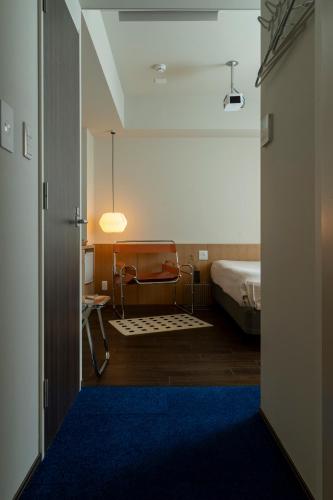 a view of a bedroom with a bed and a blue rug at etoe Hotel Shinjuku in Tokyo