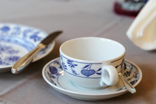 a blue and white cup and saucer on a table at Hotel Bergland in Sillian