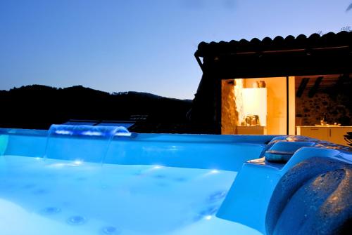 une vue d'une piscine bleue avec une maison en arrière-plan dans l'établissement Exklusives Studio inmitten wunderschöner Natur, à Lentillères