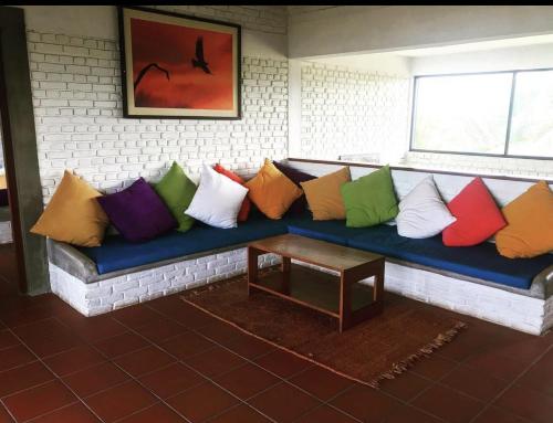a blue couch with colorful pillows on it at The Beach House Kalpitiya in Puttalam