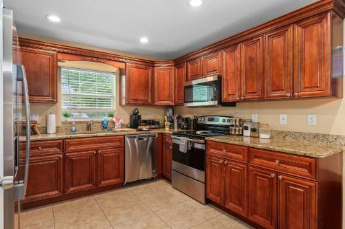 a kitchen with wooden cabinets and stainless steel appliances at Channel Side, Down Town Tampa ,Ybor Palmetto Beach, Hot tub, with pickle ball court in Tampa