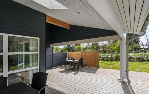 a patio with a table and chairs on a house at Stunning Home In Væggerløse With Wifi in Marielyst