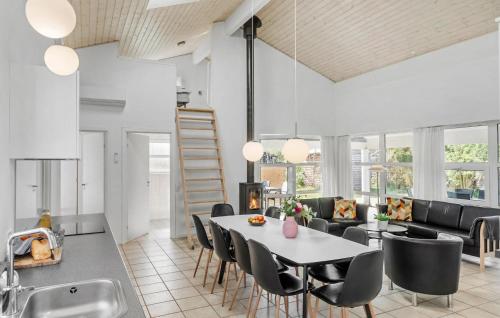 a kitchen and living room with a table and chairs at Stunning Home In Væggerløse With Wifi in Marielyst