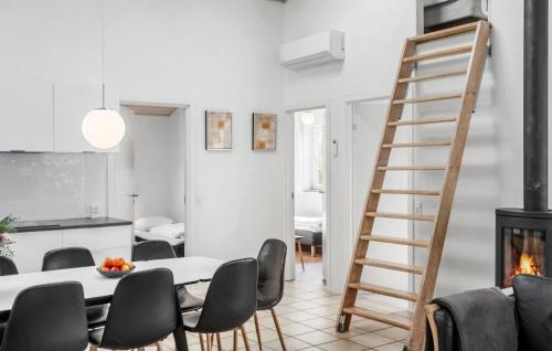 a kitchen and living room with a ladder and a table and chairs at Stunning Home In Væggerløse With Wifi in Marielyst