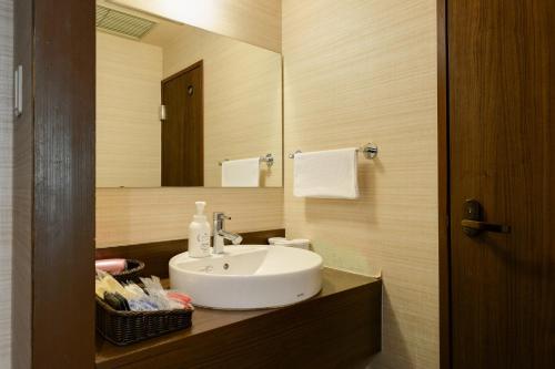 a bathroom with a white sink and a mirror at Diamond Hakone Society in Hakone